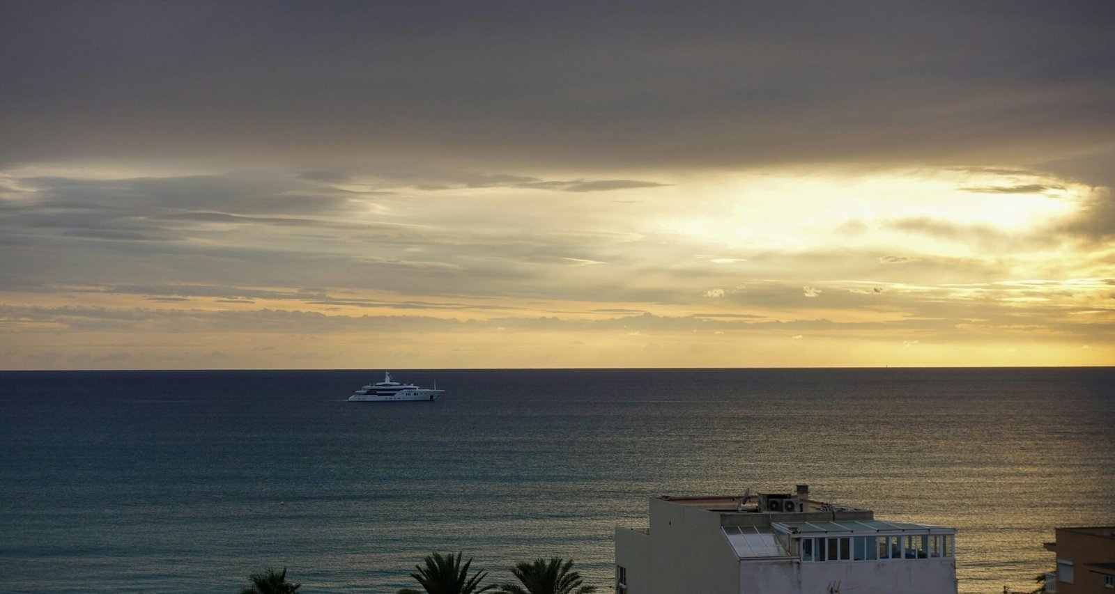 Ein Boot auf Mallorca im offenen Meer bei bewölktem Himmel, fotografiert von Yan Ots