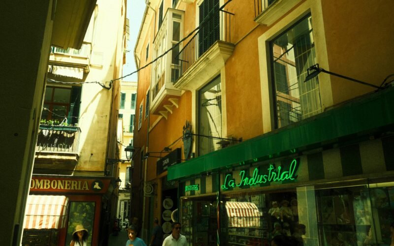 Gruppe von Menschen läuft die Straße entlang neben hohen Gebäuden auf Mallorca, aufgenommen von Felix.