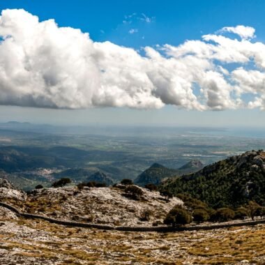 Weiße Wolken schweben über den braunen Bergen auf Mallorca, aufgenommen von David Vives.