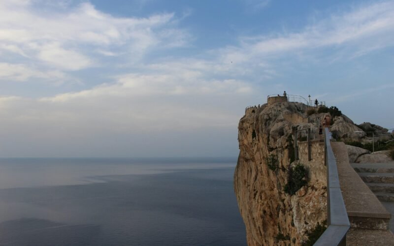 Braune Felsformation nahe Wasser während des Tages auf Mallorca, aufgenommen von Morio Kajiwara