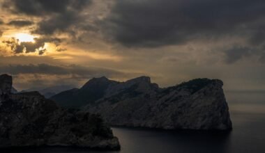 Felsige Küste auf Mallorca unter dunklem, stürmischem Sonnenuntergangshimmel, fotografiert von Tim Bernhard