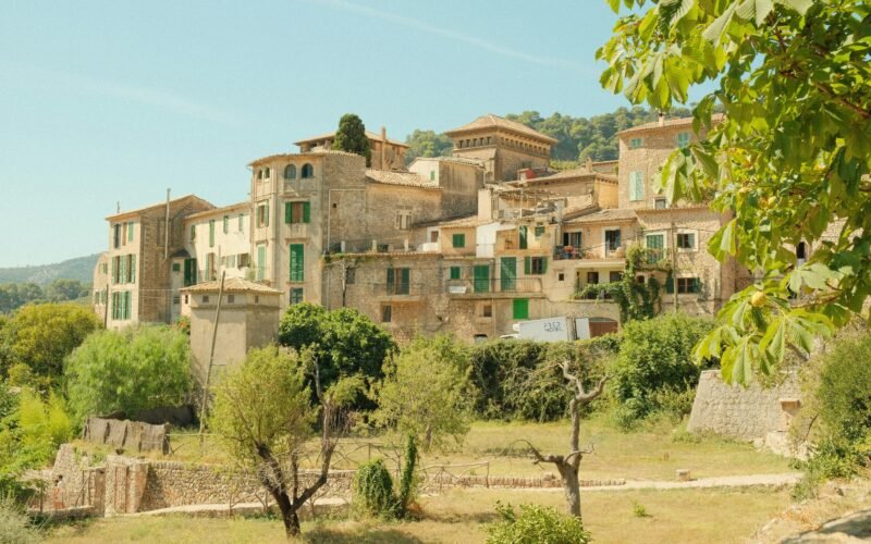 Ein Dorf mit vielen Gebäuden und Bäumen auf Mallorca, aufgenommen von Alex.