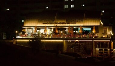 Ein beleuchtetes Restaurant am Flussufer auf Mallorca bei Nacht, mit warmem Licht und ruhiger Atmosphäre