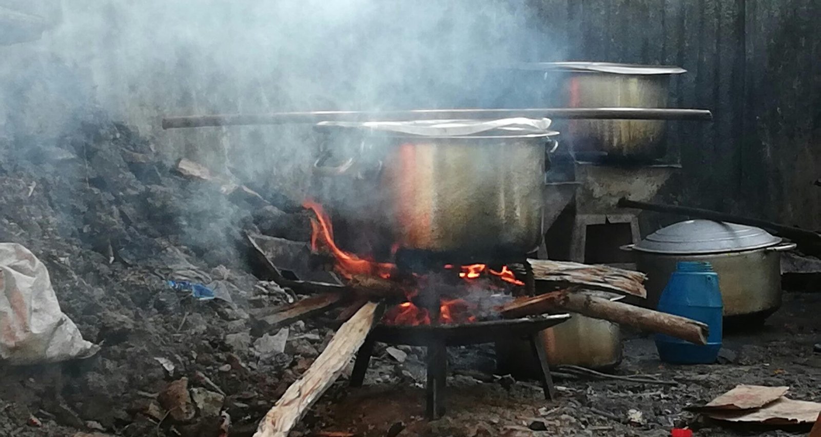 Grauer Metallkochtopf auf Mallorca auf einem Holzfeuer, das zum traditionellen Kochen genutzt wird