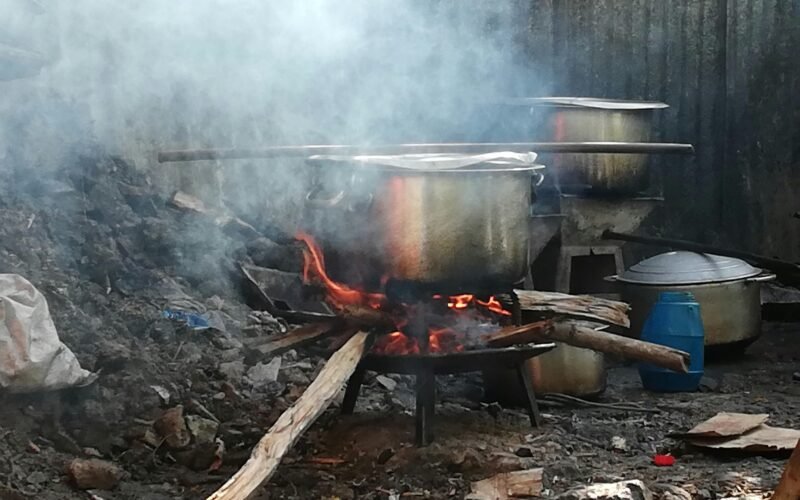 Grauer Metallkochtopf auf Mallorca auf einem Holzfeuer, das zum traditionellen Kochen genutzt wird