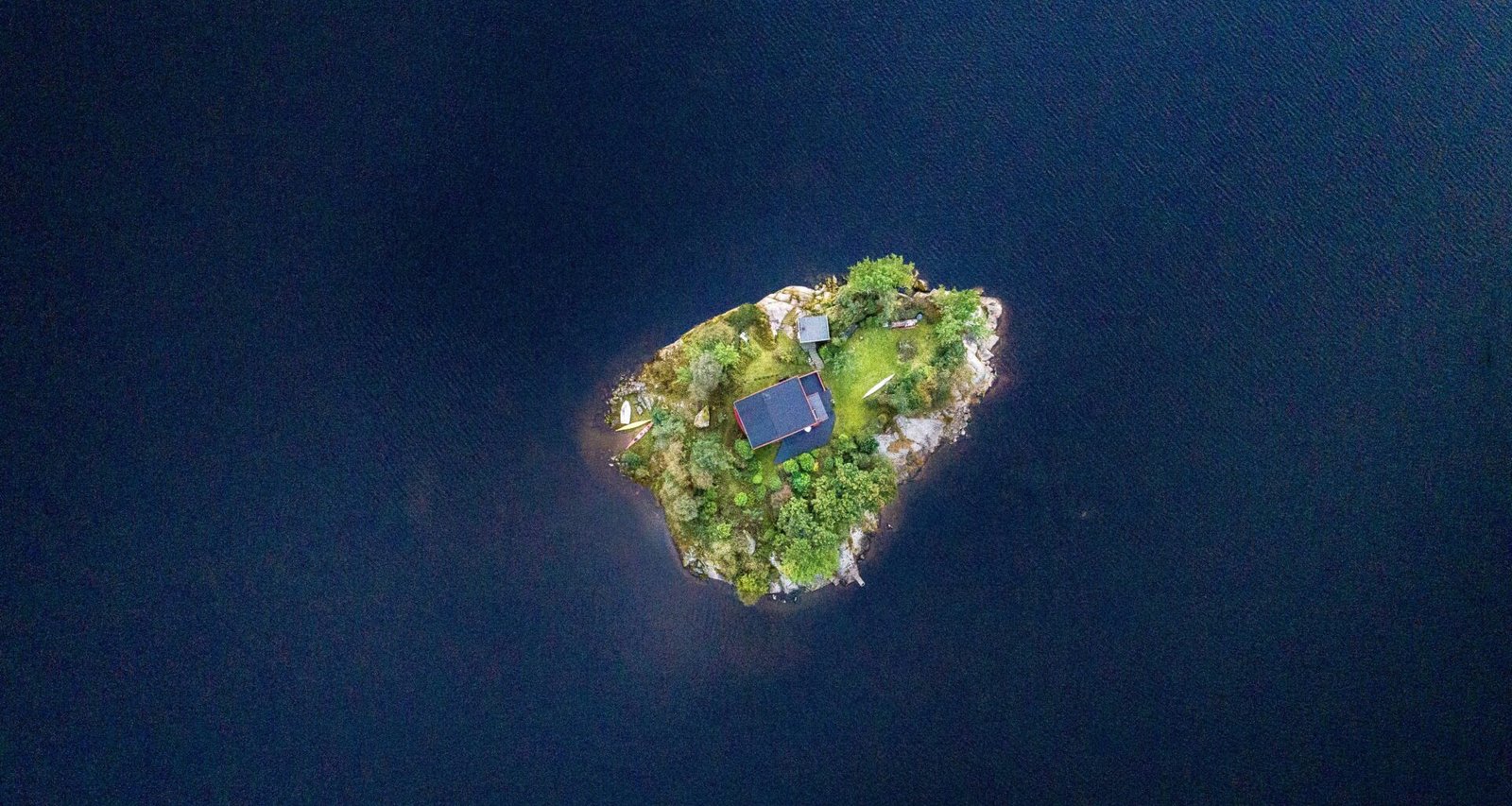 Luftaufnahme eines blauen Gebäudes in der Mitte einer Insel auf Mallorca, aufgenommen von Thomas Griesbeck