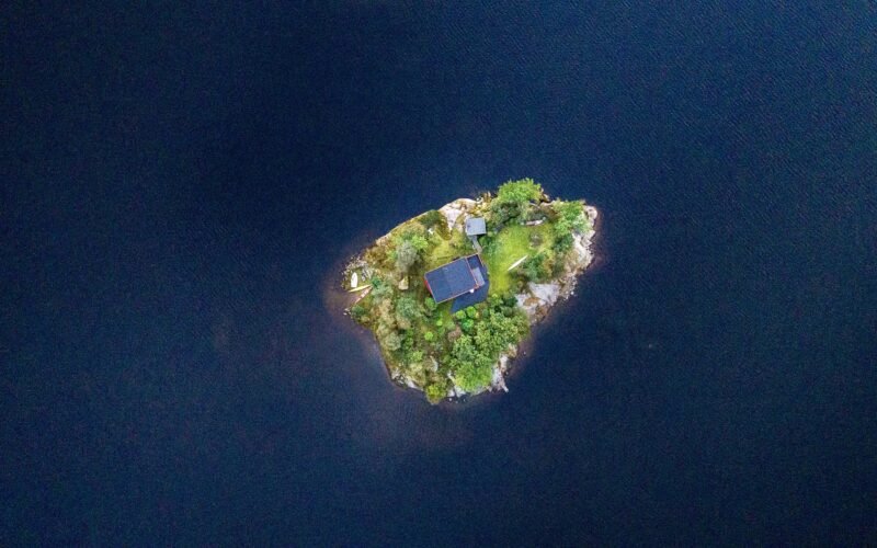 Luftaufnahme eines blauen Gebäudes in der Mitte einer Insel auf Mallorca, aufgenommen von Thomas Griesbeck
