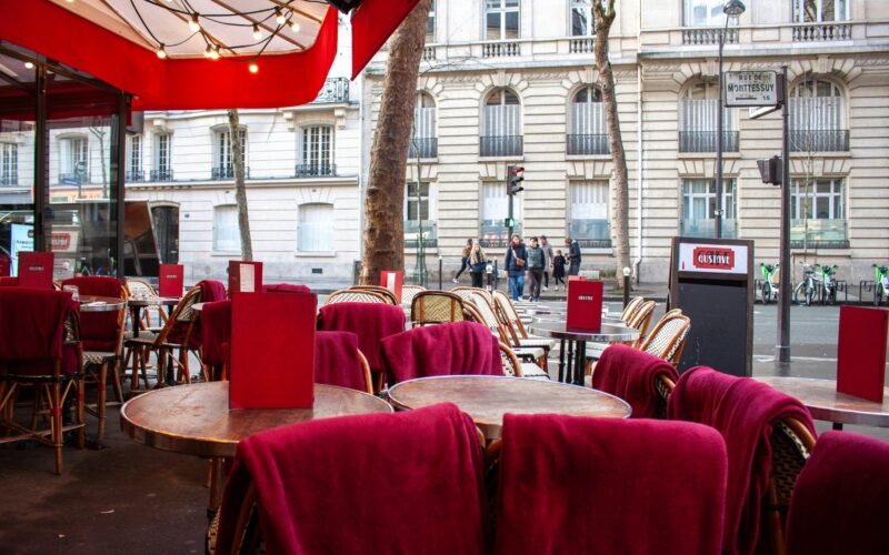 Außen-Café mit roten Stühlen und Tischen auf Mallorca, ideal für einen entspannten Aufenthalt im Freien