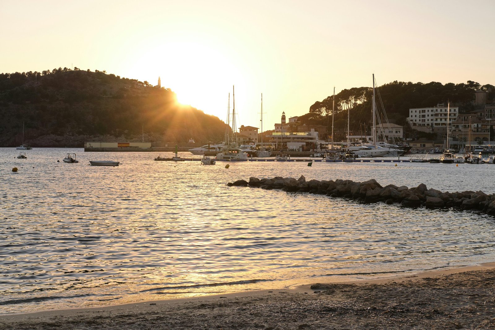 Sonnenuntergang über einem ruhigen Hafen auf Mallorca mit Yachten im Wasser