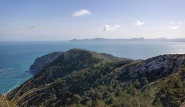 Blick auf das Meer auf Mallorca von einem Hügel aus, mit weiten Wasserflächen und Himmel im Hintergrund