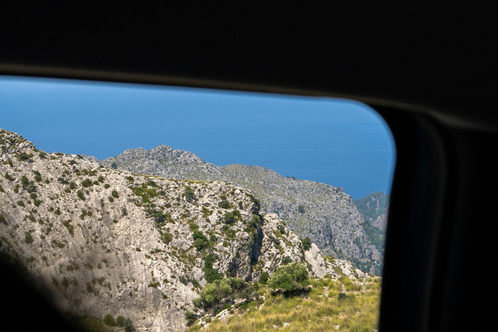 Blick auf einen Berg auf Mallorca, aufgenommen aus dem Inneren eines Fahrzeugs, mit Blick durch das Fenster