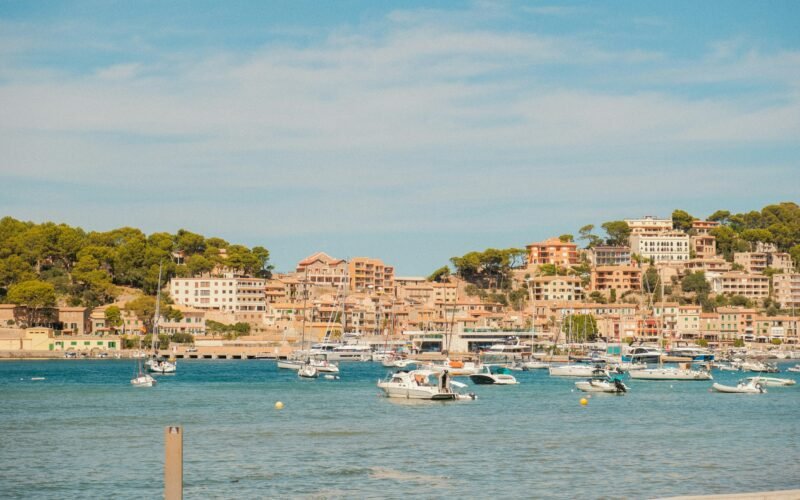 Boote im Hafen auf Mallorca mit Blick auf die Stadt auf dem Hügel, aufgenommen von Alexis Presa.