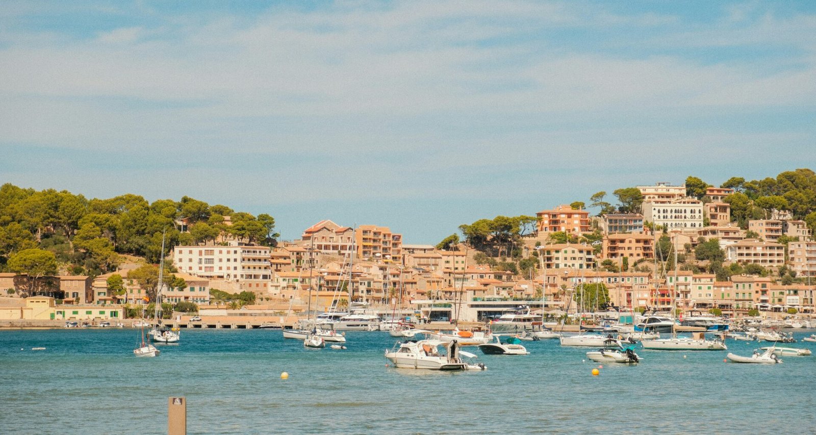 Boote im Hafen auf Mallorca mit Blick auf die Stadt auf einem Hügel im Hintergrund