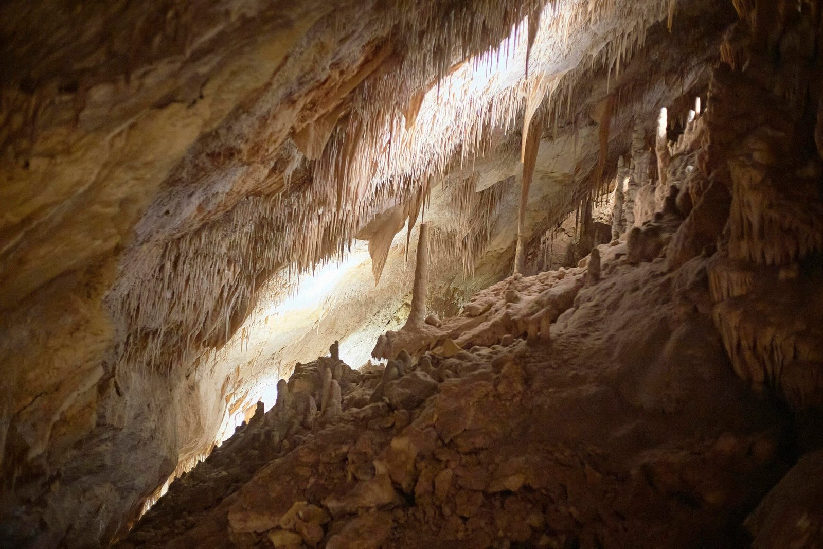 Blick in eine braune und weiße Höhle auf Mallorca bei Tageslicht, zeigt die natürlichen Gesteinsformationen