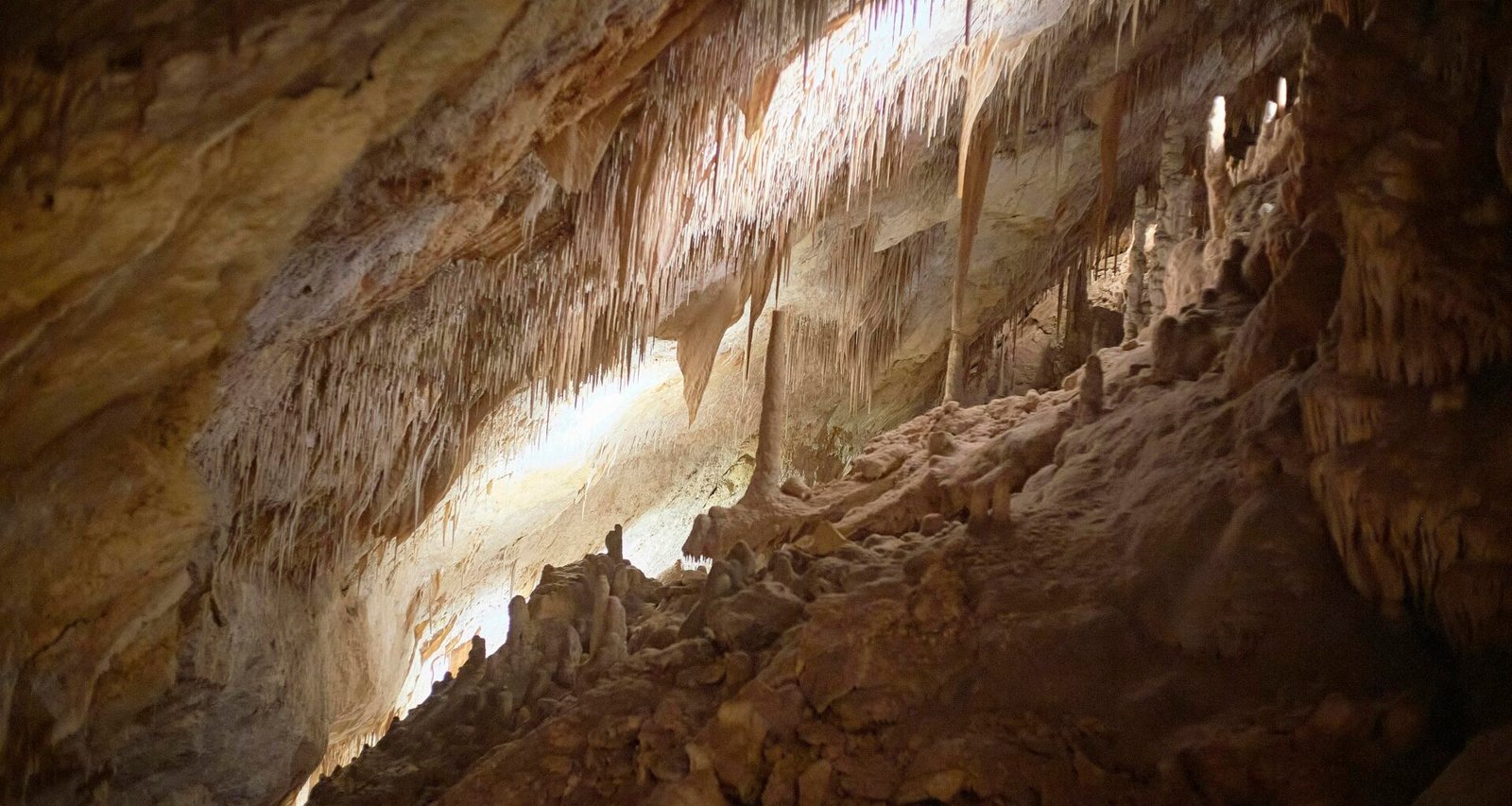 Bunte Höhle mit braunen und weißen Felsformationen auf Mallorca bei Tageslicht