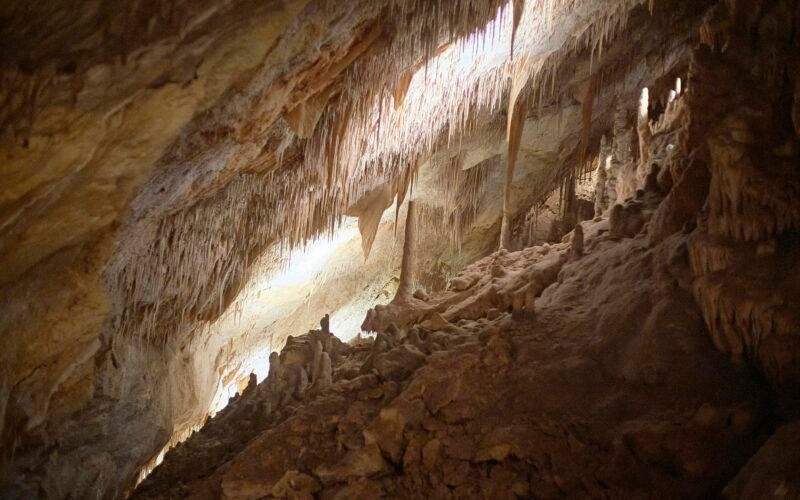 Bunte Höhle mit braunen und weißen Felsformationen auf Mallorca bei Tageslicht