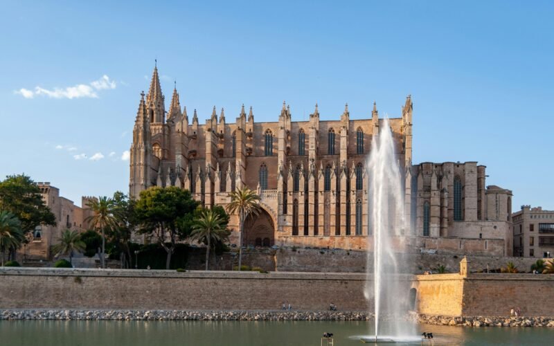 Braunes Betongebäude nahe Wasserbrunnen während des Tages auf Mallorca, fotografiert von David Vives.