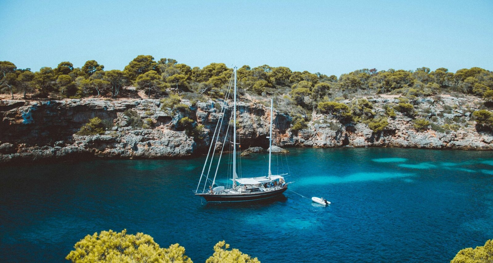 Braunes und weißes Segelboot auf Mallorca treibt ruhig im Mittelmeer, fotografiert von Michael Heuser.