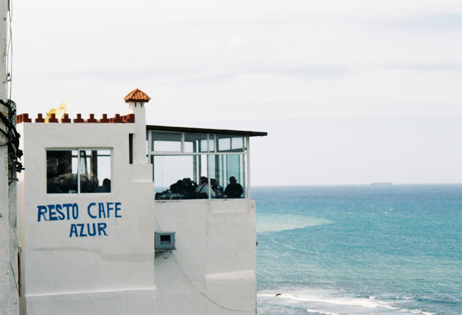 Café auf Mallorca mit Blick auf den Ozean und dem Schild 'resto cafe azur', fotografiert von Amina.