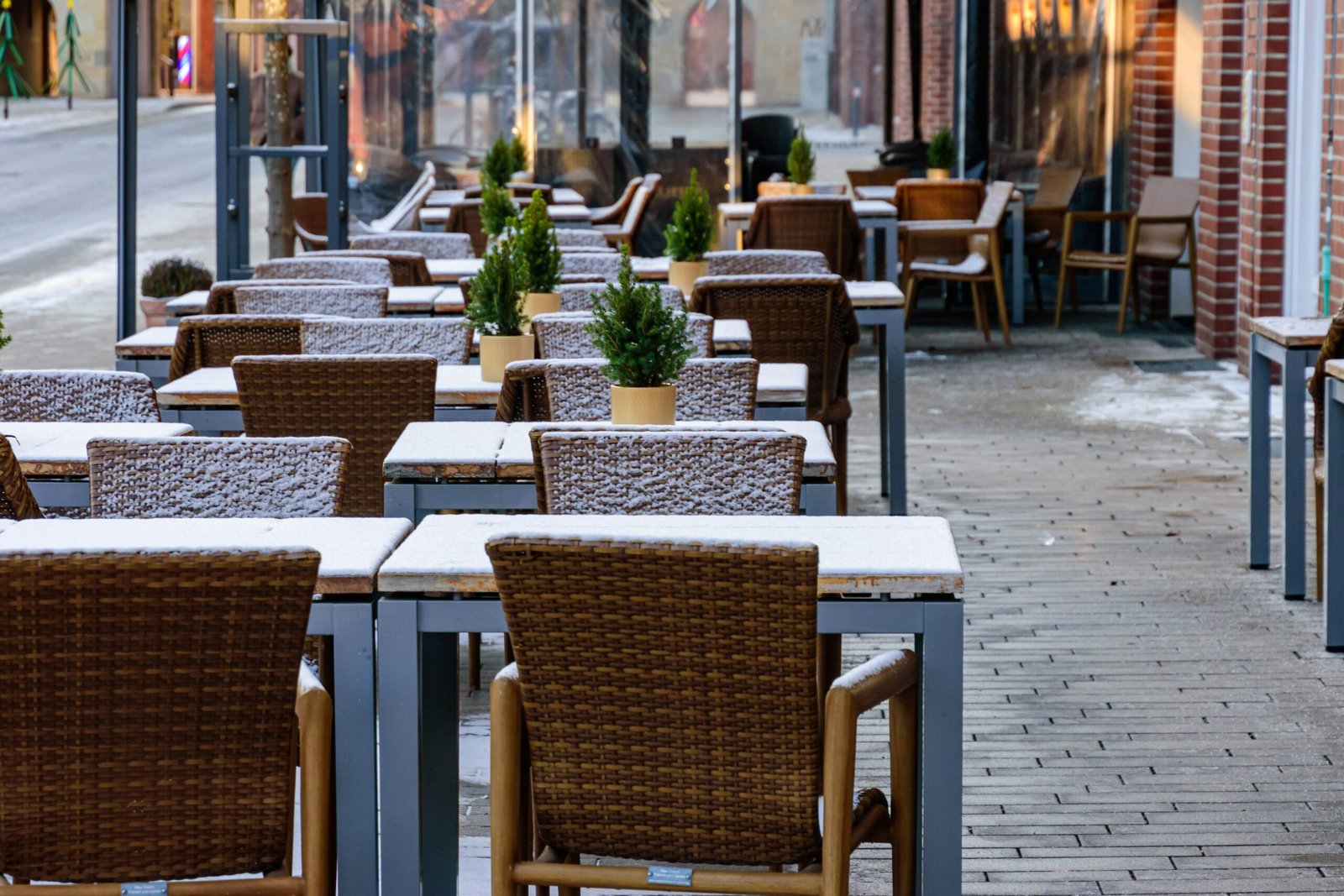 Outdoor-Café auf Mallorca mit Tischen und Stühlen, die leicht mit Schnee bedeckt sind, aufgenommen von Sergej Karpow.