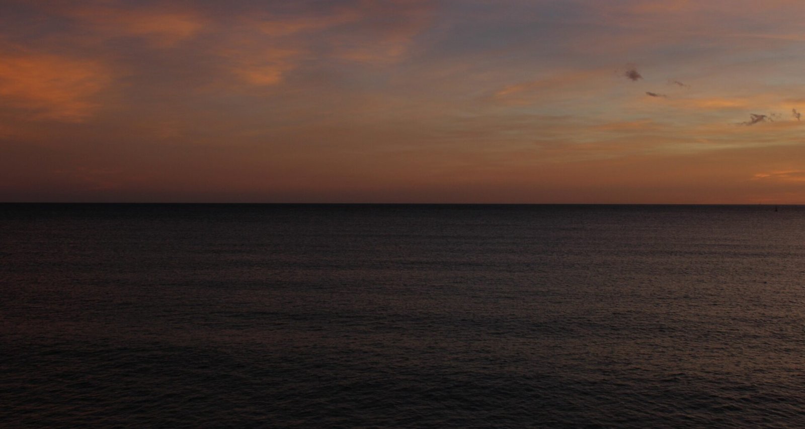 Der Sonnenuntergang malt den Himmel über dem dunklen Meer auf Mallorca, fotografiert von Susana Bartolome.