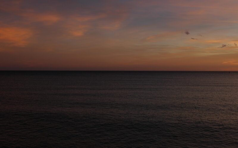 Der Sonnenuntergang malt den Himmel über dem dunklen Meer auf Mallorca, fotografiert von Susana Bartolome.