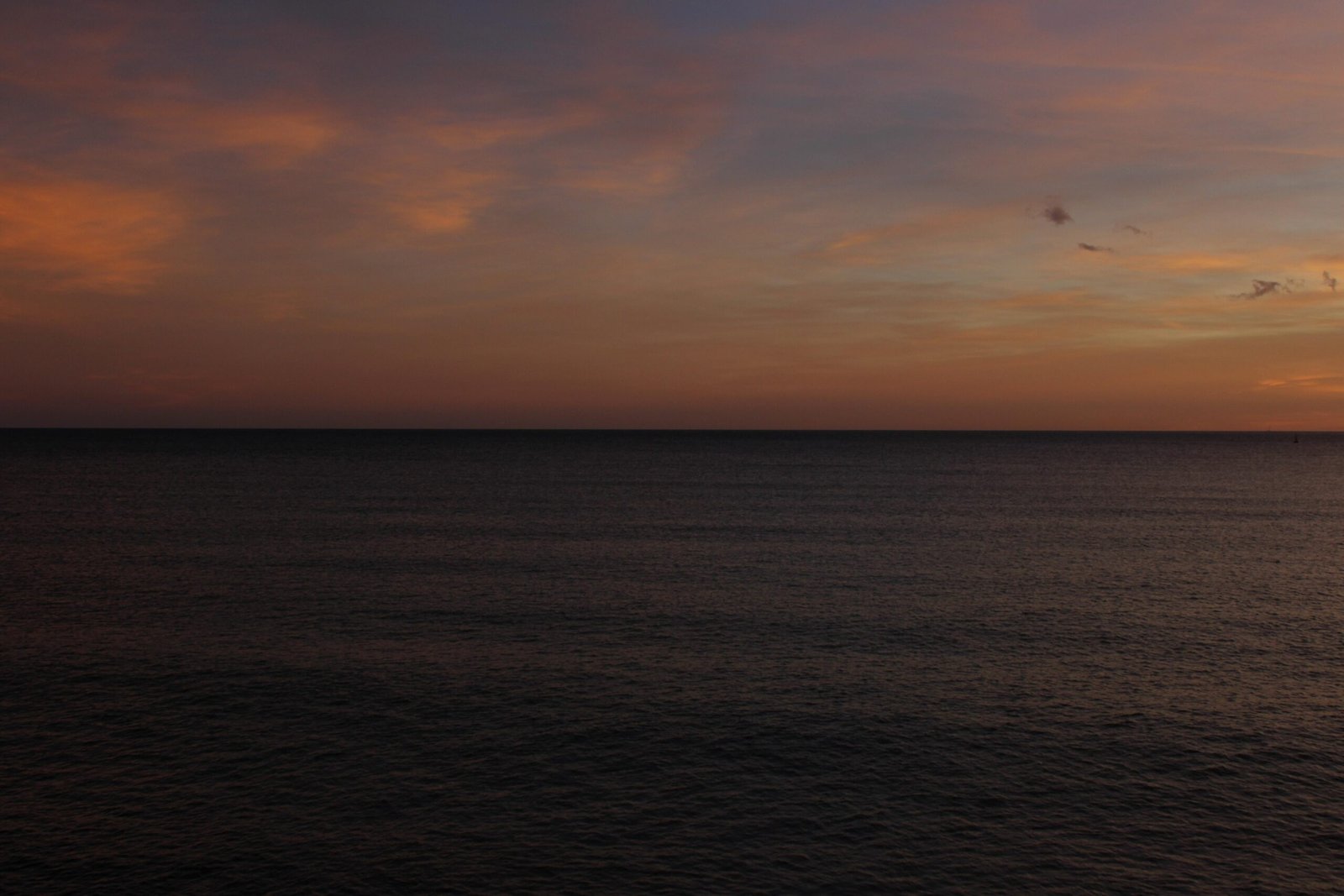 Der Sonnenuntergang malt den Himmel über dem dunklen Meer auf Mallorca, fotografiert von Susana Bartolome.