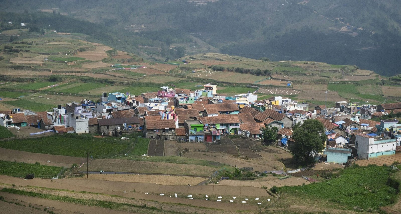 Dorf auf Mallorca eingebettet in die Berge mit umliegenden Feldern, aufgenommen von Ajin K S