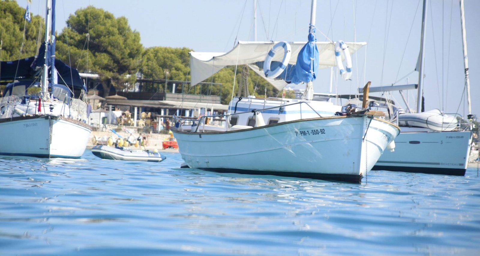 Drei Segelboote treiben auf Mallorca auf ruhigem Wasser, aufgenommen von Miquel Gelabert.