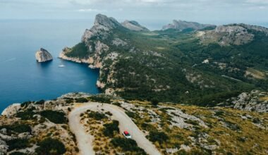 Ein Auto fährt auf Mallorca auf einer Straße in der Nähe von Bergen, aufgenommen von Austin Farrington.