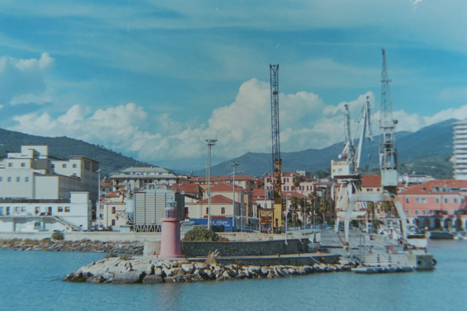Hafen mit Leuchtturm im Vordergrund auf Mallorca, aufgenommen von Piermario Eva, zeigt die Küstenlandschaft
