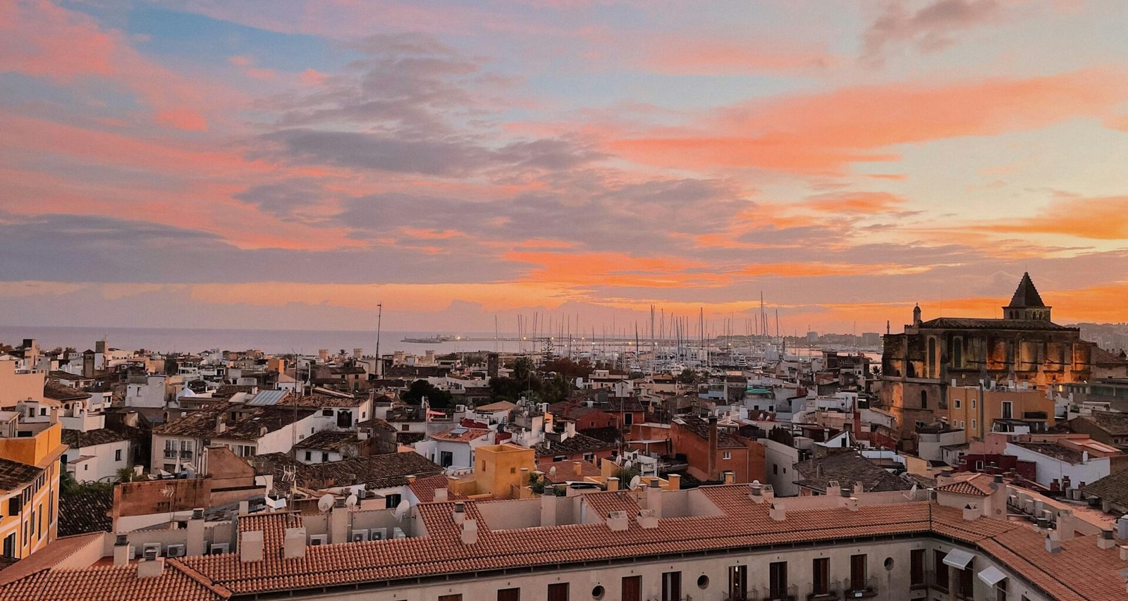 Sonnenuntergang über eine Stadt auf Mallorca, aufgenommen von Oscar Nord, vom Dach aus gesehen