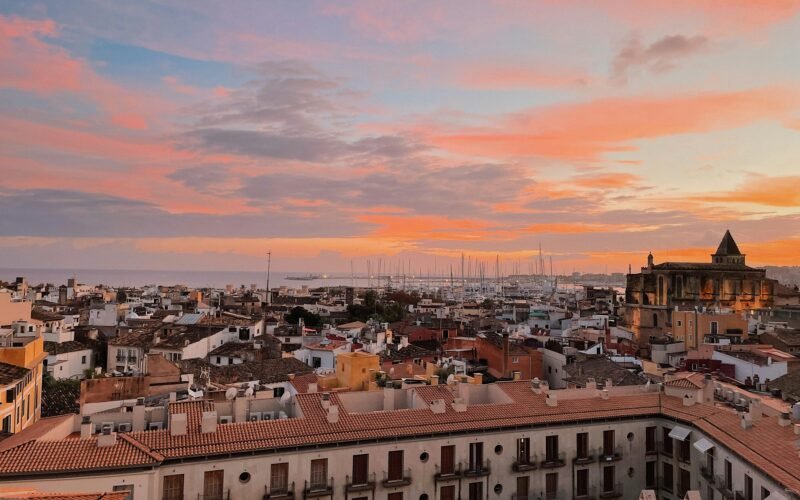 Sonnenuntergang über eine Stadt auf Mallorca, aufgenommen von Oscar Nord, vom Dach aus gesehen