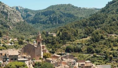Dorf auf Mallorca eingebettet zwischen grünen Bergen, aufgenommen von Nick Andreas