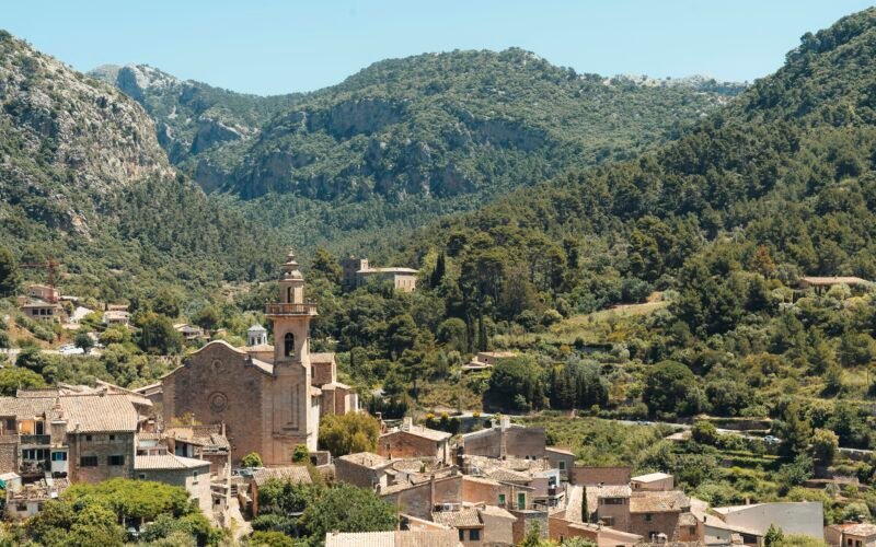 Dorf auf Mallorca eingebettet zwischen grünen Bergen, umgeben von Natur und Landschaft