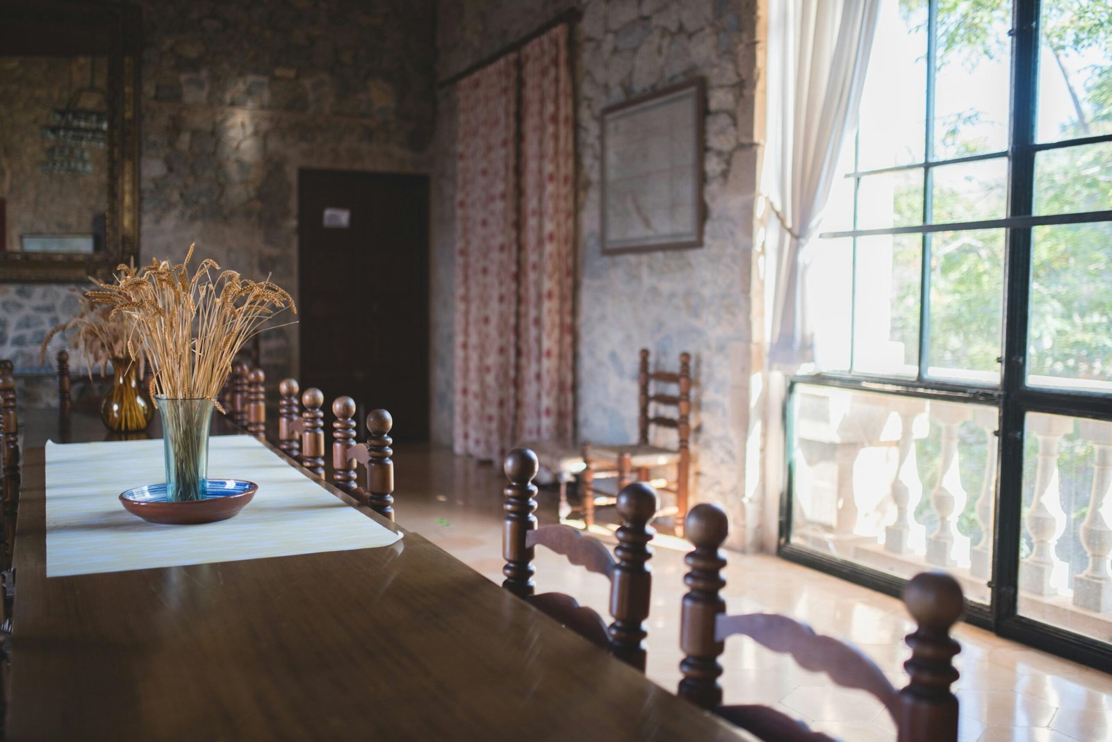 Ein Esstisch in einem Esszimmer auf Mallorca mit einer Vase voller Blumen, fotografiert von Monika Guzikowska.