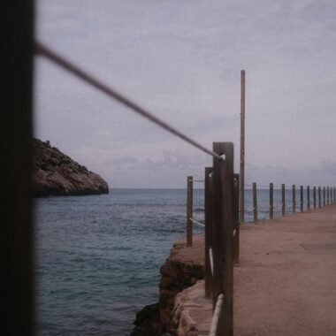Ein Gehweg mit Geländer entlang der Küste auf Mallorca, Blick auf das Meer im Hintergrund, fotografiert von Marius Matuschzik.