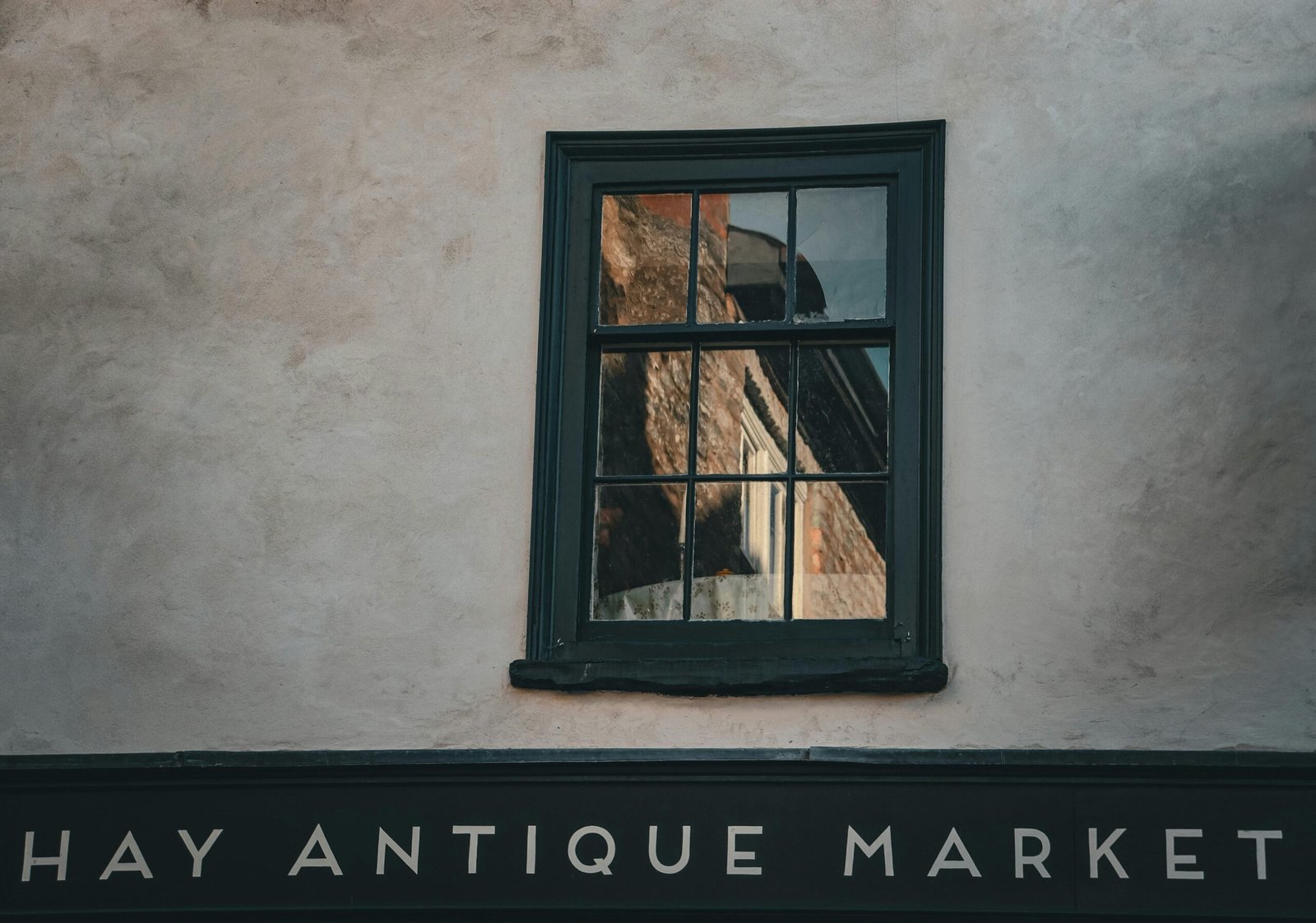 Gebäude mit einem Fenster, das den Antique Market auf Mallorca anzeigt, fotografiert von Yukon Haughton
