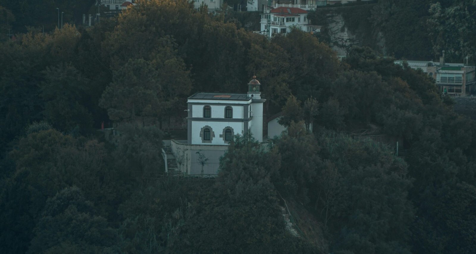 Ein Gebäude auf Mallorca, umgeben von Bäumen, in einer natürlichen Umgebung fotografiert von Leon Kohle