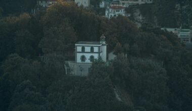 Ein Gebäude auf Mallorca, umgeben von Bäumen, in einer natürlichen Umgebung fotografiert von Leon Kohle