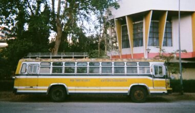 Gelber und weißer Bus parkt vor einem Gebäude auf Mallorca, fotografiert von narue sri