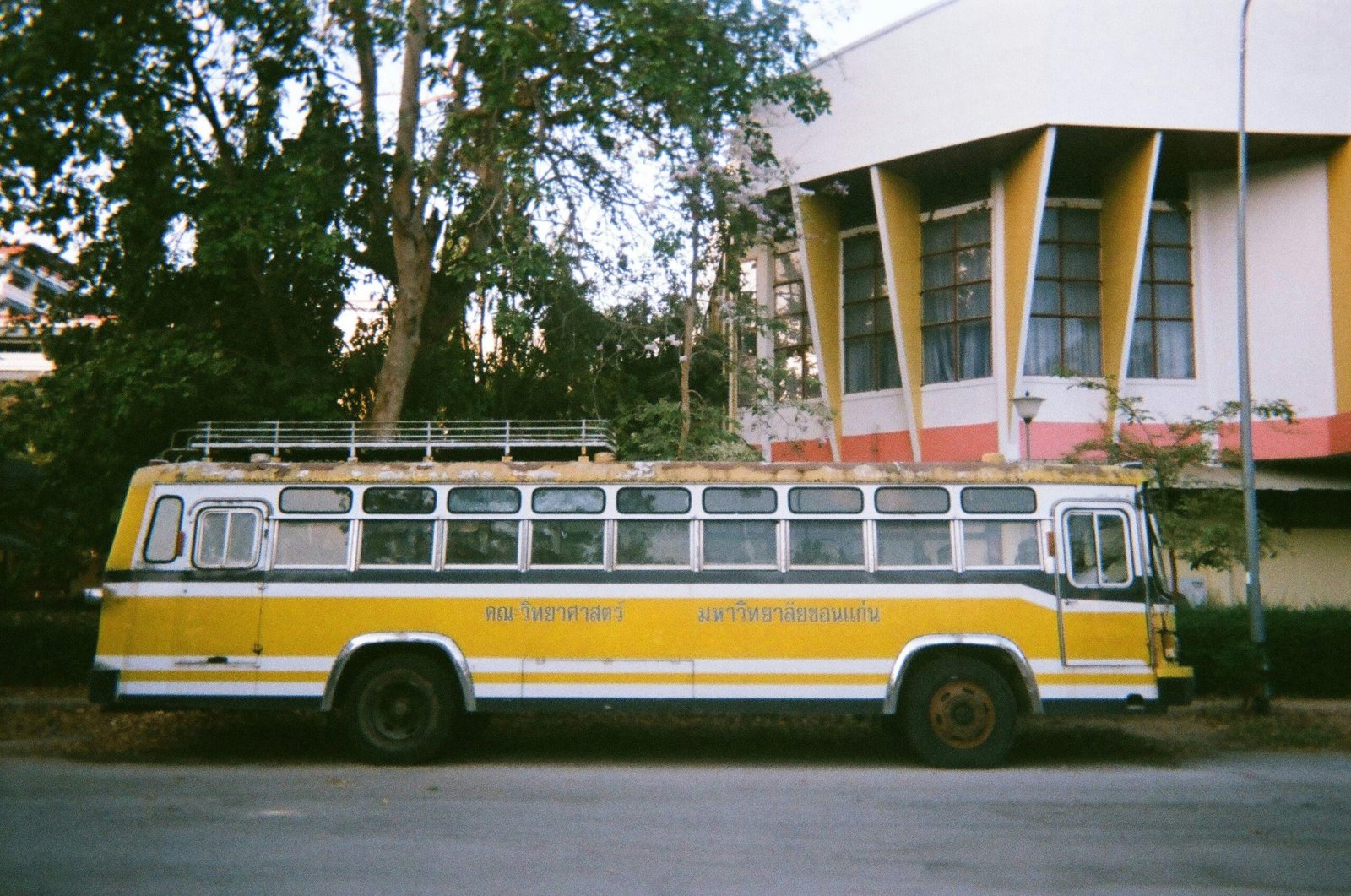 Gelber und weißer Bus parkt vor einem Gebäude auf Mallorca, fotografiert von narue sri