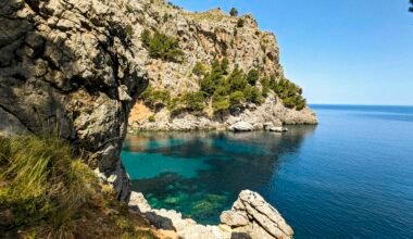 Klares Wasser vor einer felsigen Klippe auf Mallorca, aufgenommen von Andre Blanco, zeigt die natürliche Küstenlandschaft.