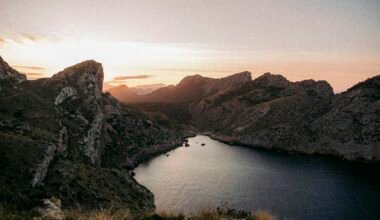 Ein ruhiges Gewässer mit Bergen im Hintergrund auf Mallorca, aufgenommen von Colin + Meg.