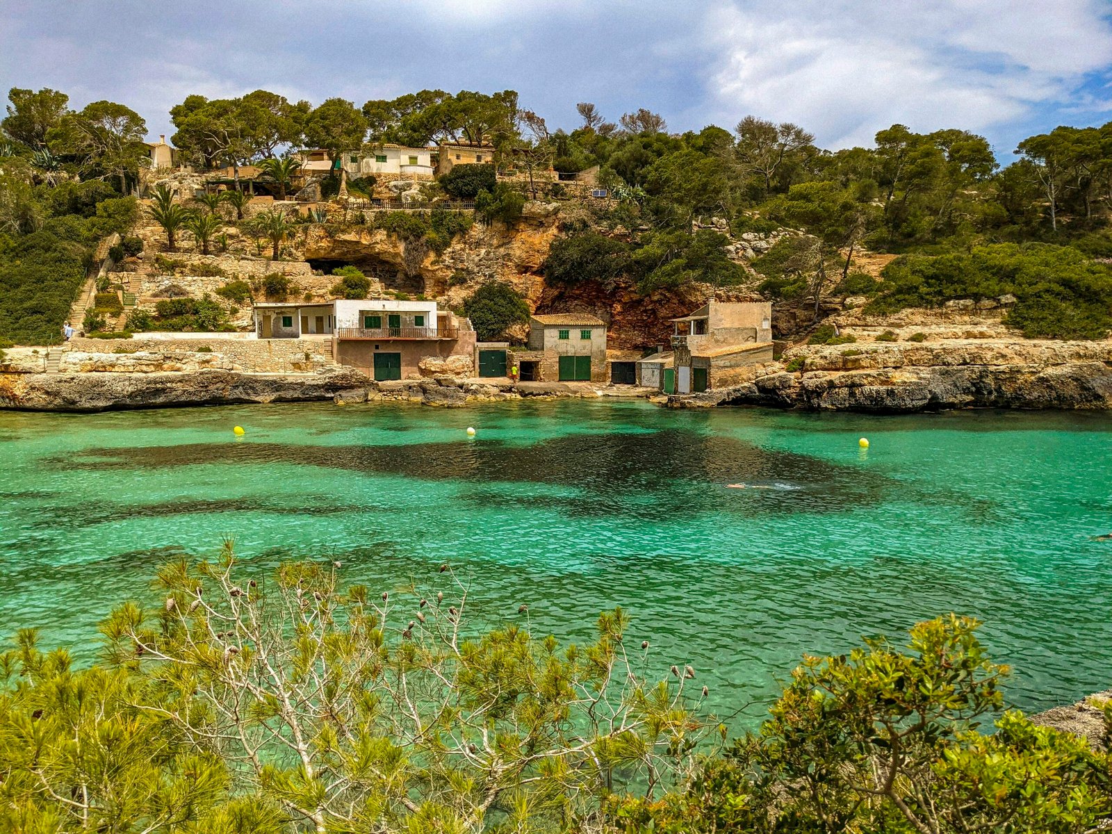 Ein Wasserfeld mit einem Haus auf einem Hügel im Hintergrund auf Mallorca, fotografiert von Andre Blanco.