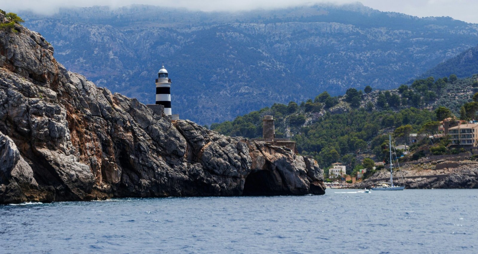 Leuchtturm auf Mallorca auf einem Wasserbecken mit Blick auf das offene Wasser, aufgenommen von Artur Łuczka.