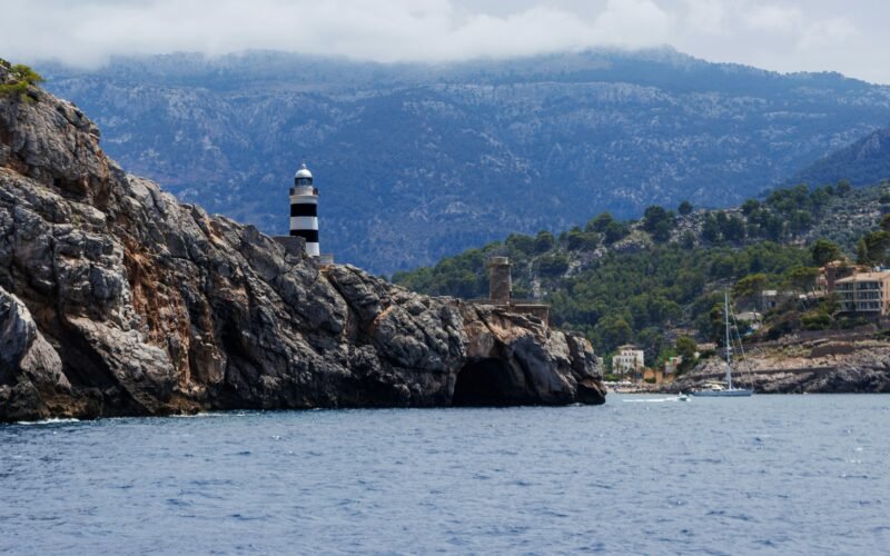 Leuchtturm auf Mallorca auf einem Wasserbecken mit Blick auf das offene Wasser, aufgenommen von Artur Łuczka.