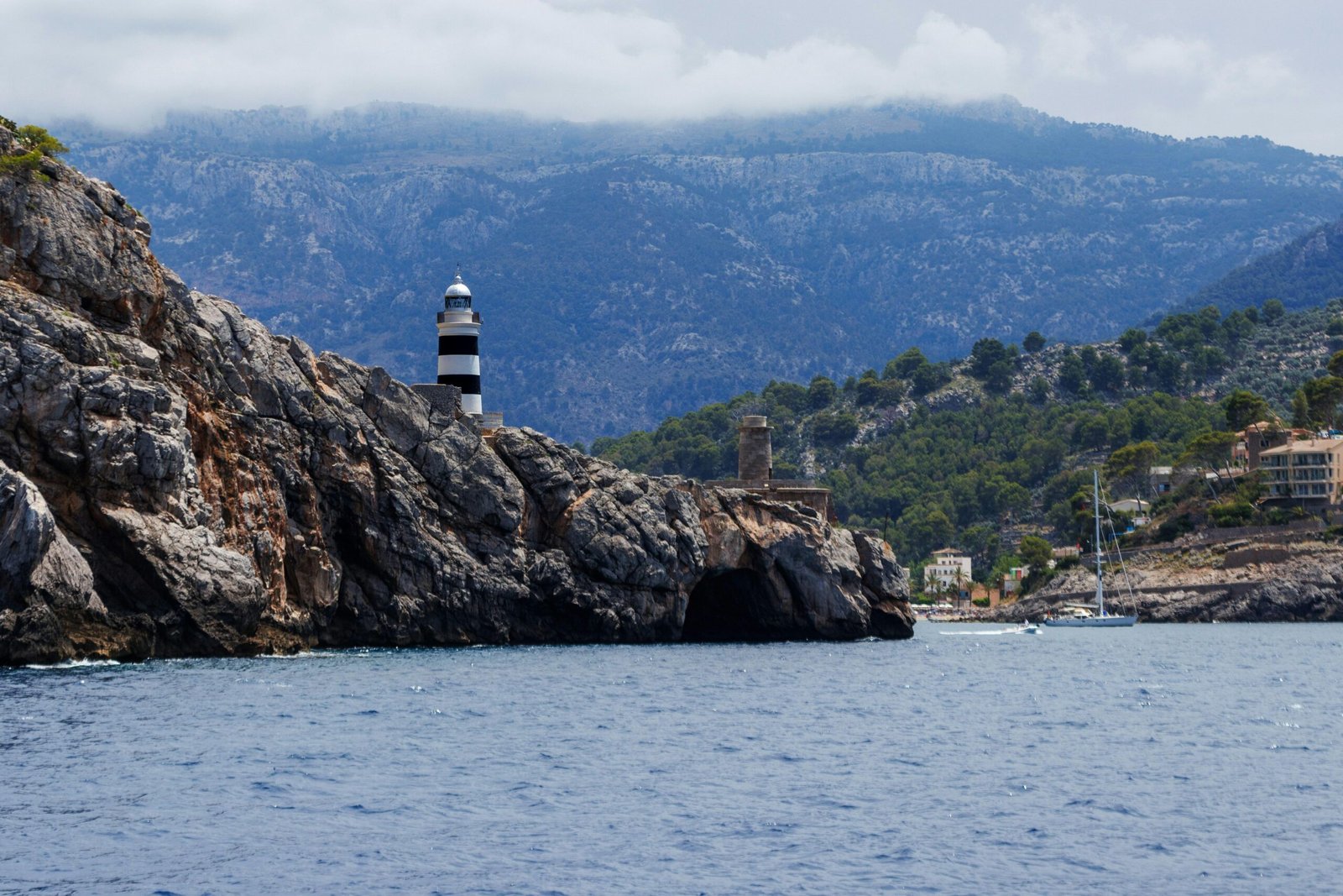 Leuchtturm auf Mallorca auf einem Wasserbecken mit Blick auf das offene Wasser, aufgenommen von Artur Łuczka.