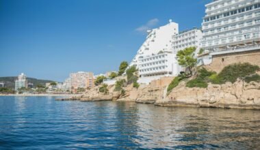 Wasser mit Gebäuden auf Mallorca, aufgenommen von Monika Guzikowska, zeigt die Küstenarchitektur und das Gewässer der Insel
