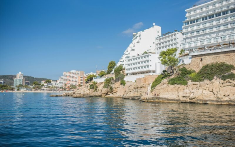 Wasser mit Gebäuden auf Mallorca, aufgenommen von Monika Guzikowska, zeigt die Küstenarchitektur und das Gewässer der Insel